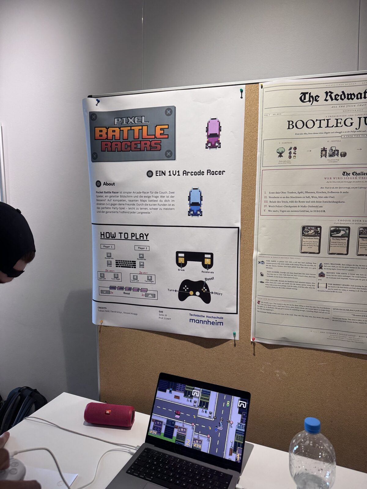 Posters at the stands: Pixel Battle Racers next to the newspaper-style poster of Bootleg Juice & Co.